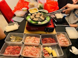 A group preparing Mookata Thai food on a table from self pick up set meals